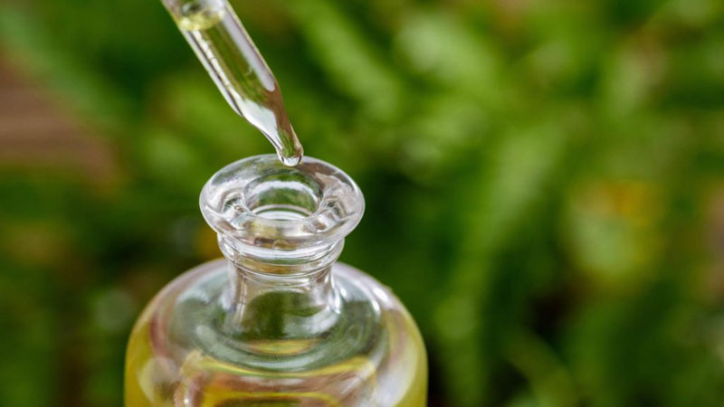 CBD oil from hemp dropping into a glass bottle 