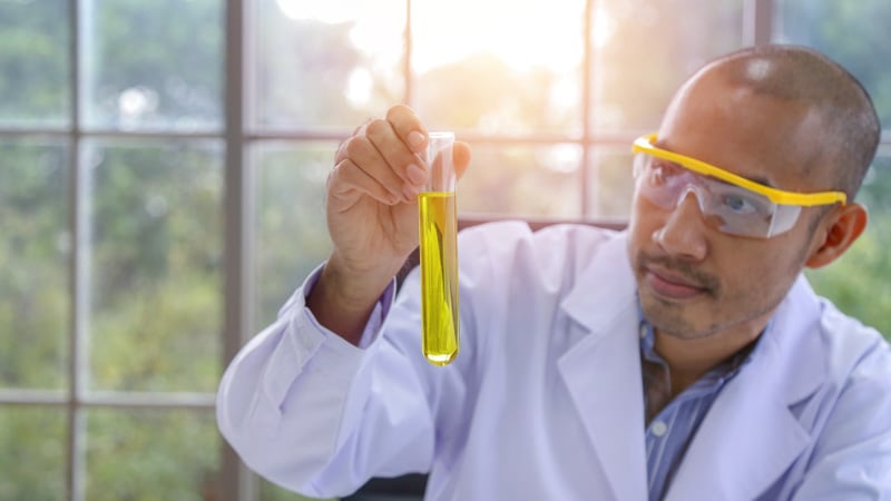 A male scientist looking at CBD oil extracted with organic solvent method