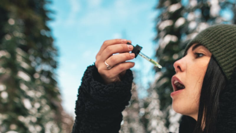 A woman taking CBD oil in the snow forest in North Dakota