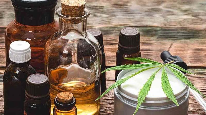 Various types of CBD products next to a hemp leaf 