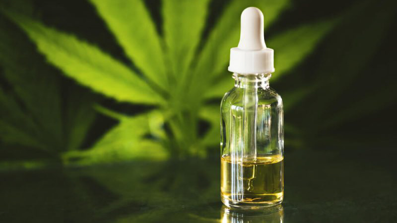 CBD oil bottle and hemp leaf