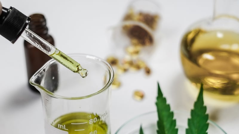 CBD oil and capsules on white table