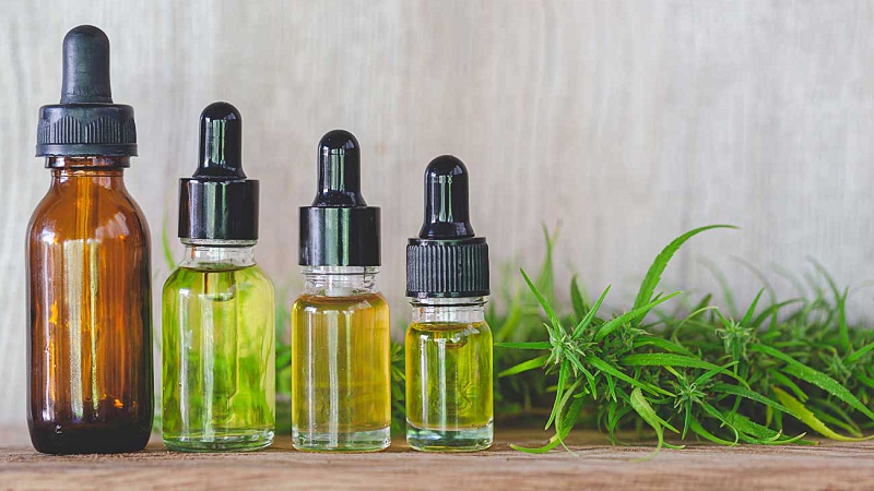 Bottles of cannabis extract with hemp leaves on a table