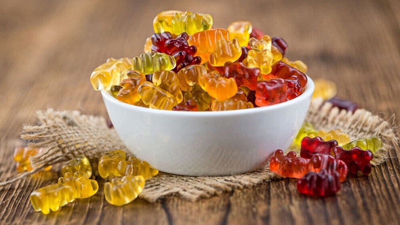 a bowl full of CBD gummies placed on a small rag on a wooden table