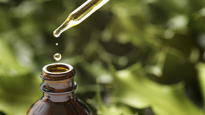 taking CBD oil from a bottle using a dropper