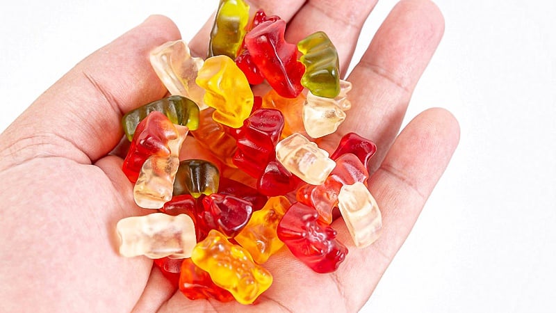 close-up image of a hand full of CBD gummies in assorted colors 