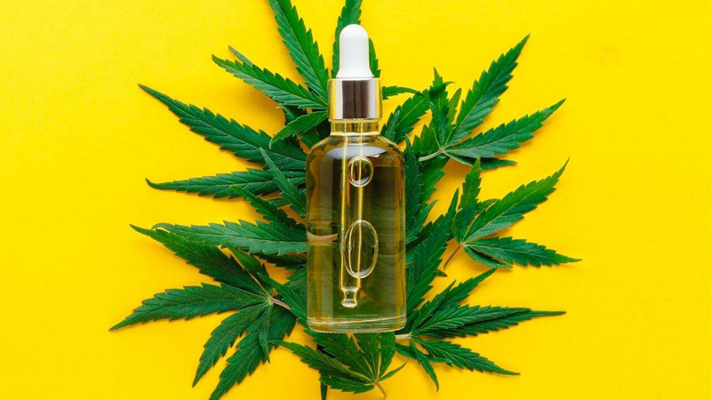 CBD Oil with Hemp Leaves Background