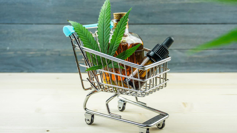 CBD oil bottles with a hemp leaves on a cart.