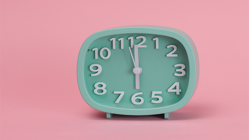 Image of clock in pink background